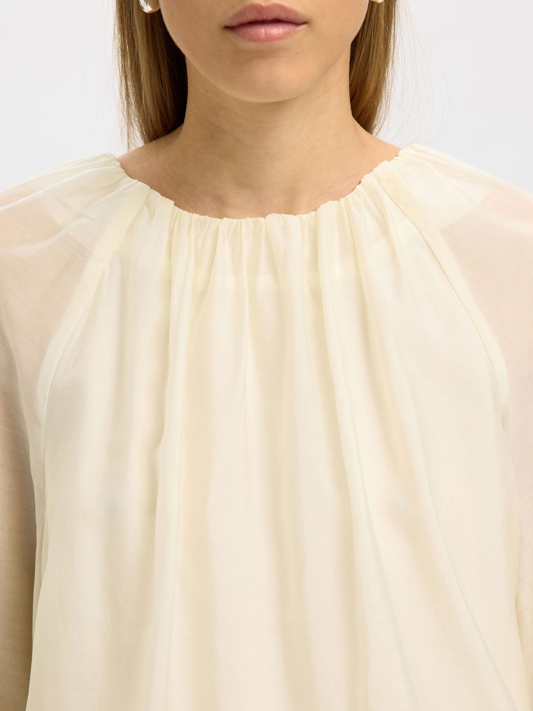 HALF DOORSCHIJNEND BLOUSE MET LANGE MOUWEN